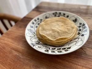 白い皿に重ねられた焼き上がりのライ麦入りクレープ