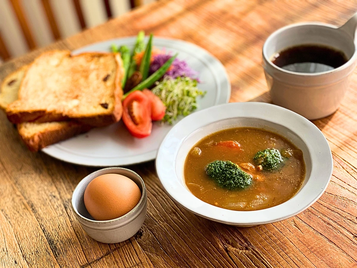 チキンシチュー、トースト、コーヒー、ゆで卵の朝食。