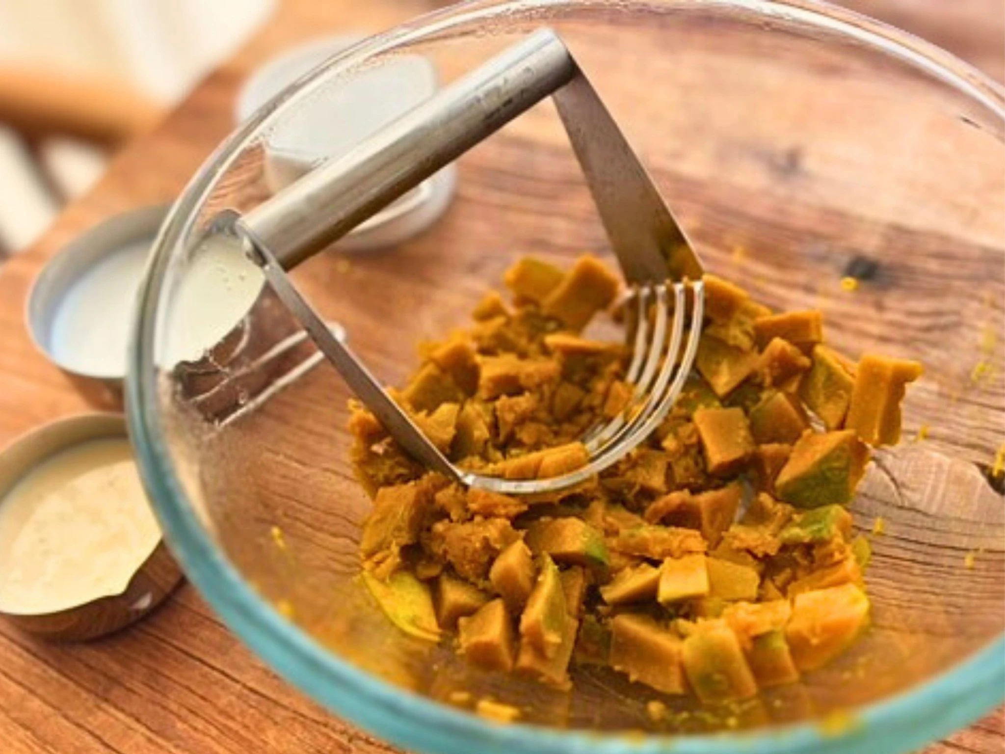 レンジで加熱したかぼちゃをマッシャーでつぶしているところ