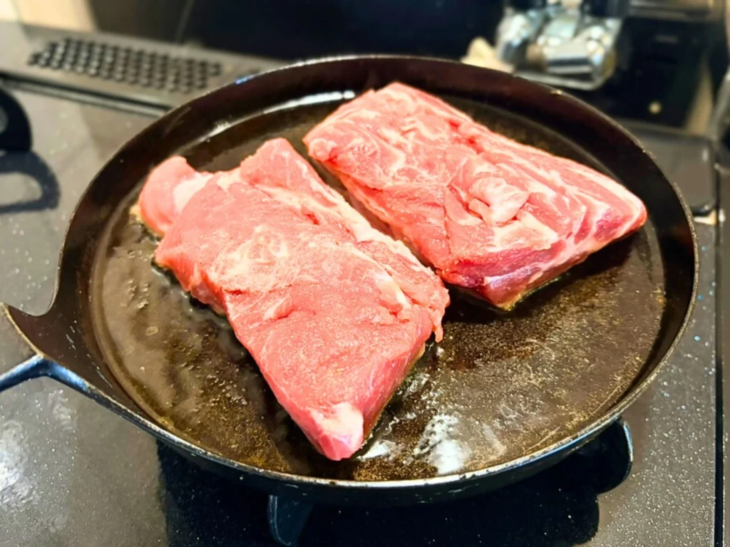 下味のついた豚肩ロース肉を焼き始めたところ