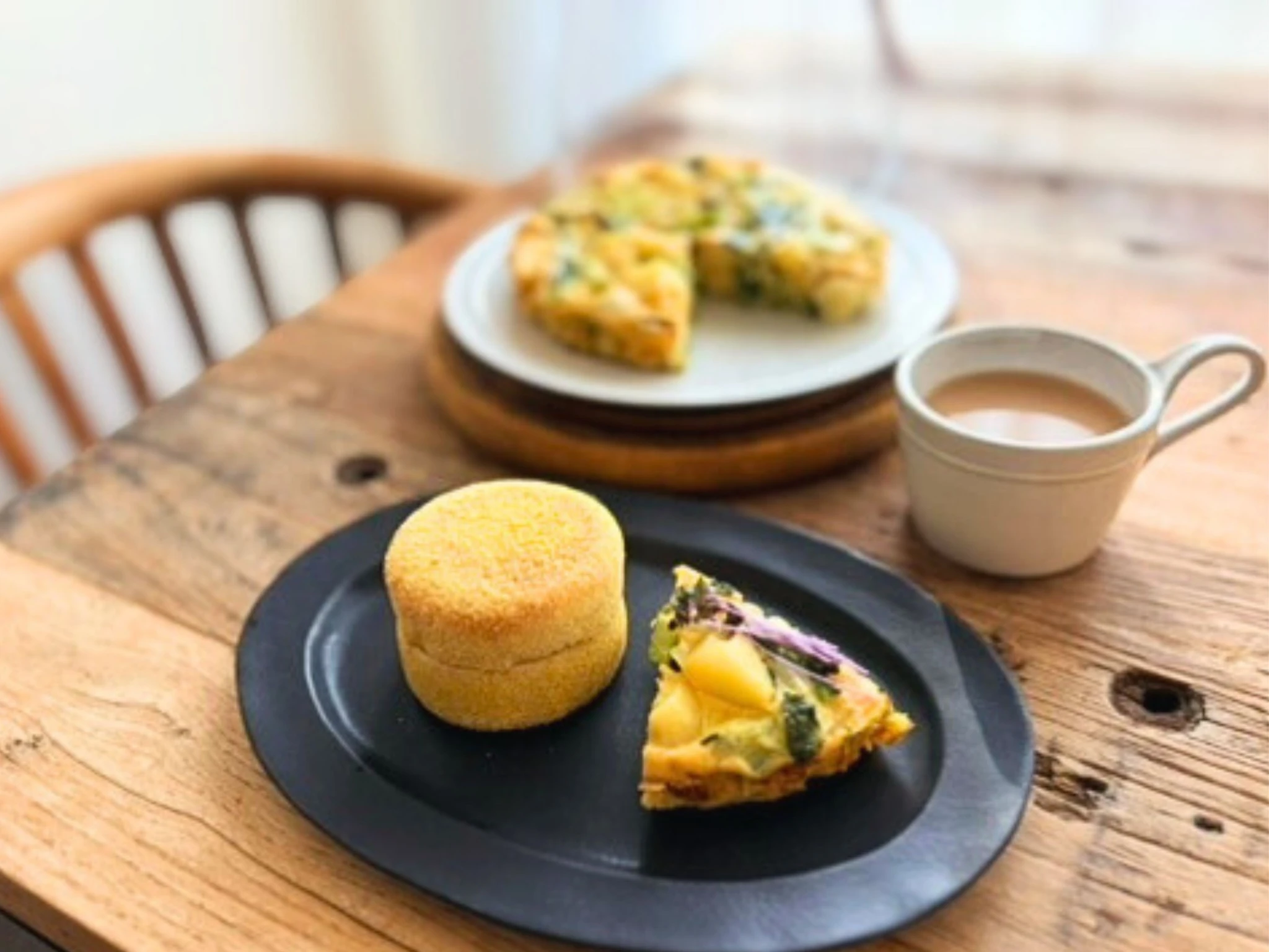 卵と野菜のケーキとイングリッシュマフィン、カフェオレを並べた朝食のテーブル