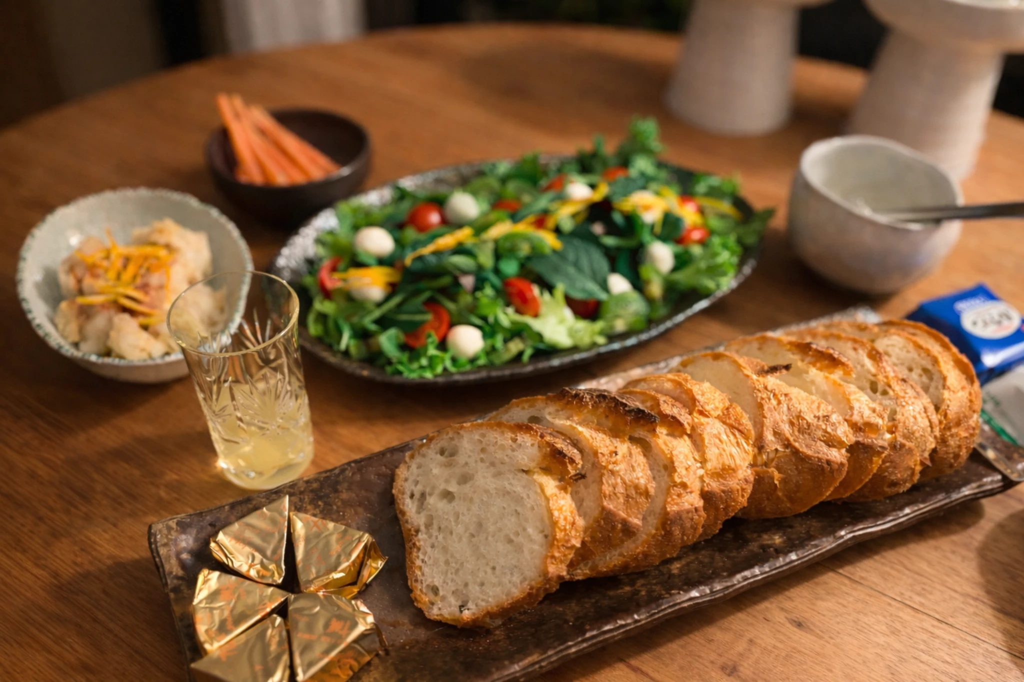 年末の夜、食卓のそばに座る2匹の猫。窓の外には夜景が広がる静かな時間