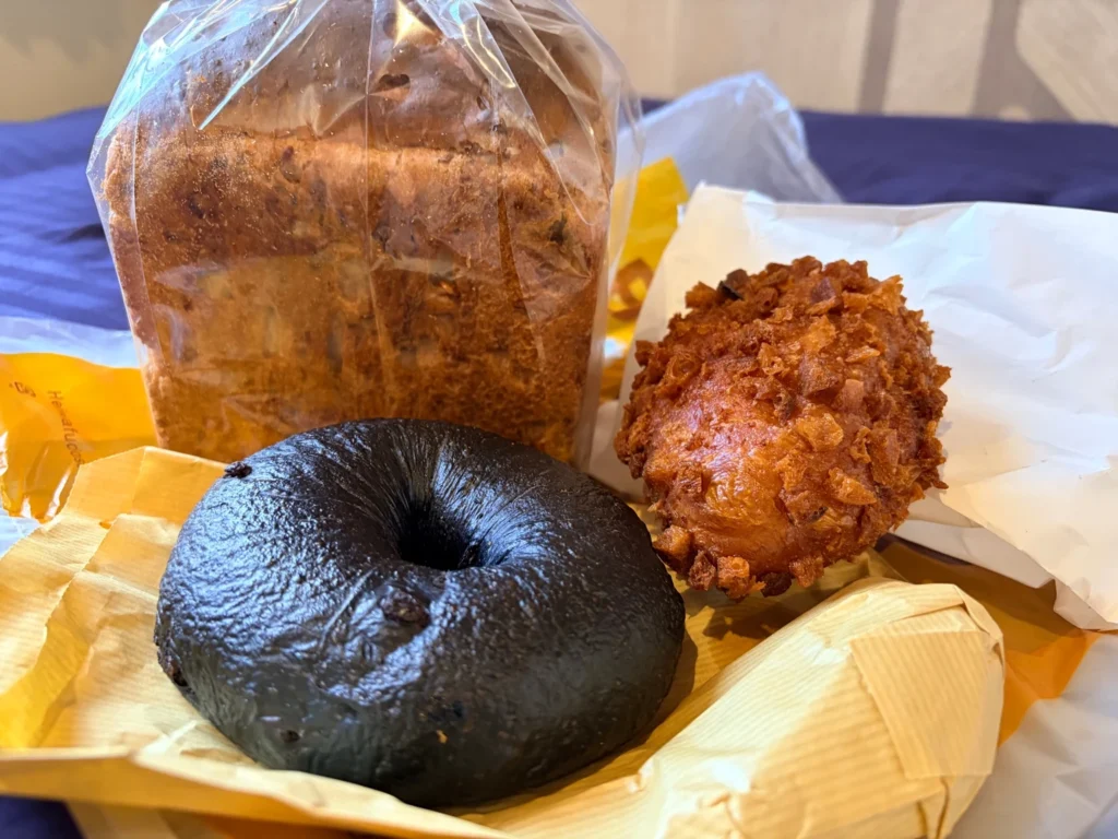 ホテルの部屋で広げたLAMPベーカリーのパン。チョコレートベーグル、カレーパン、胡桃食パン