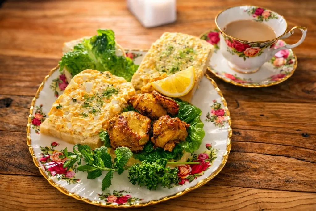 卵サンドとグリルチキンのサンド、ミルクティ。花柄のカップと皿で整えた春の夜の軽食
